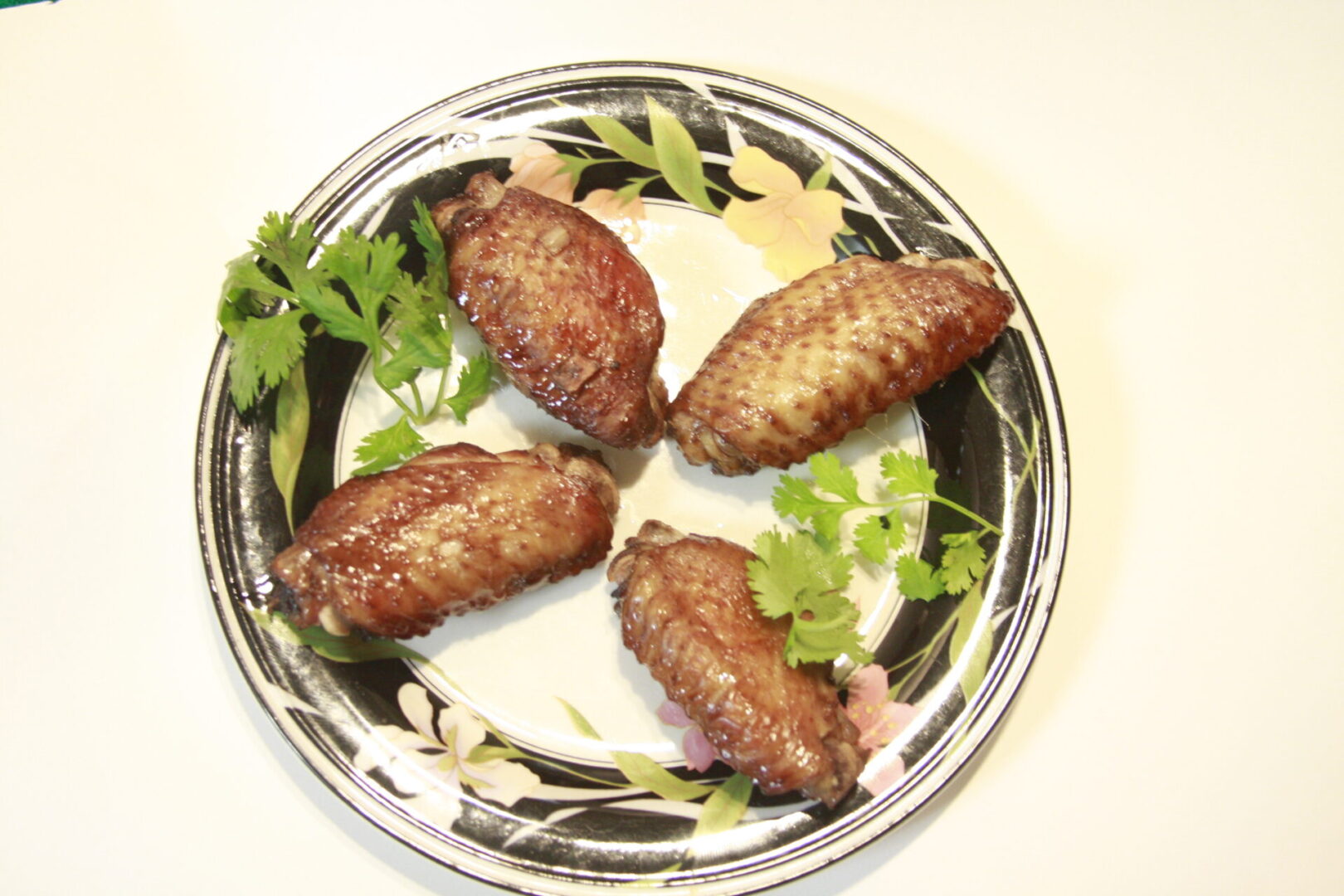 A plate with four meat on it and some parsley.