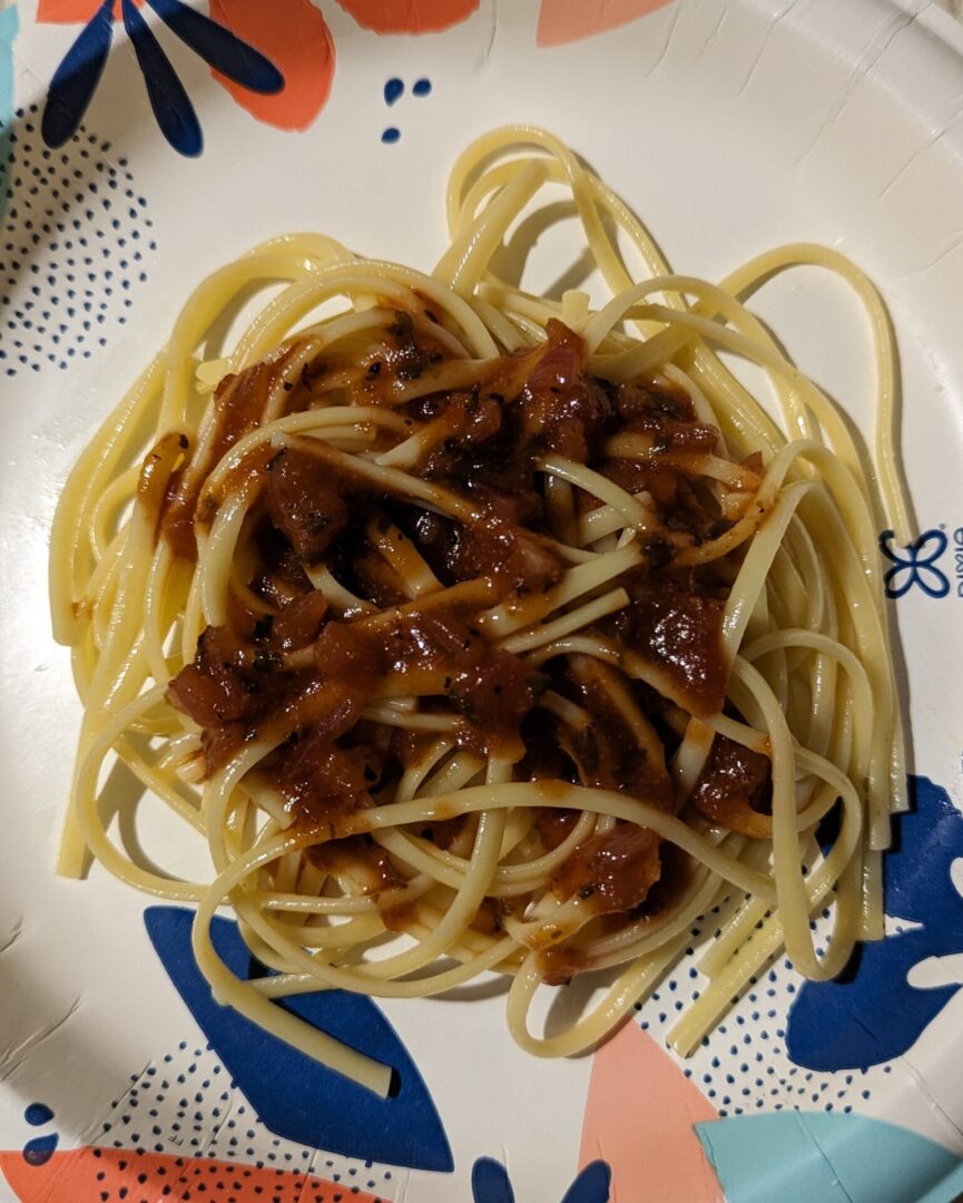 A plate of spaghetti with meat sauce on top.