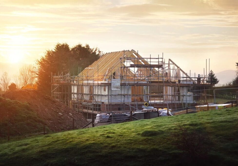 A house under construction with scaffolding on top of it.